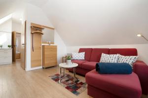 a living room with a red couch and a table at Hasenkamp 18 Krabbe in Grömitz