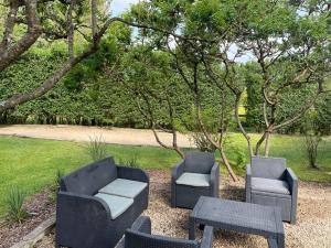 un groupe de chaises et de tables dans un jardin dans l'établissement Le Vieux Moulin, à Marche-en-Famenne