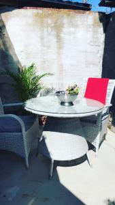 uma mesa e cadeiras com uma tigela de fruta em Split em Veberöd