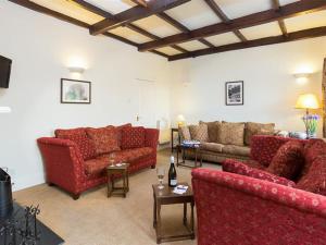 una sala de estar con 2 sofás rojos y una mesa. en 2 Hart Head Barn en Ambleside