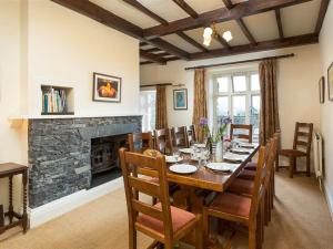 a dining room with a table and a fireplace at 2 Hart Head Barn in Ambleside