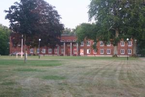 a large red brick building with trees in front of it at Söderåsen Resort in Ljungbyhed