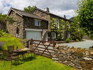 a stone house with a table and chairs in front of it at 2 Hart Head Barn in Ambleside