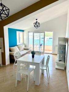 sala de estar con mesa blanca y sillas en Apartments Villa Marina en Rogoznica