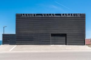 een zwart gebouw met een bord aan de zijkant bij Luxury Villas Kabakum in Goudstrand