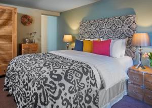 a bedroom with a black and white bed with colorful pillows at The White Hart at Lydgate in Oldham