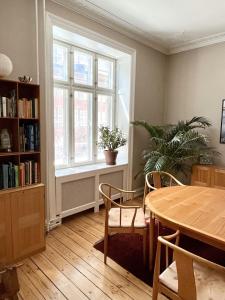 ein Wohnzimmer mit einem Tisch und einem Fenster in der Unterkunft ApartmentInCopenhagen Apartment 1279 in Kopenhagen