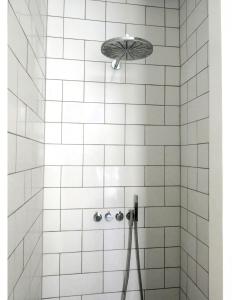 コペンハーゲンにあるApartmentInCopenhagen Apartment 1279の白いタイル張りのバスルーム(パラソル付きシャワー付)