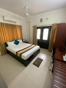 a bedroom with a bed and a desk and window at Krishna Kunja " A Quiet & Peaceful Stay " in Kolkata