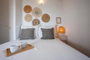 Un dormitorio con una cama con dos tazas. en Alterra Vita Captain's Cabin en Néos Marmarás