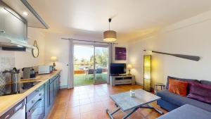 a kitchen and living room with a couch and a table at Les terrasses du Liouquet in La Ciotat