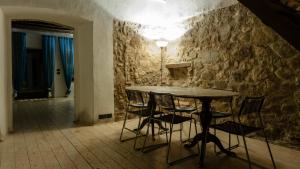 una mesa y sillas en una habitación con una pared de piedra en Agriturismo Trebisonda Country Resort, en Monzambano