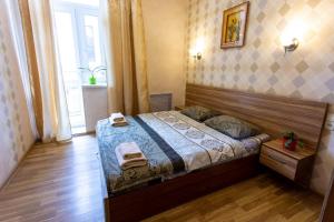 um quarto com uma cama num quarto com uma janela em Malon Apartments em Kharkov