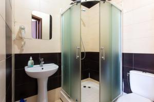 un bagno con lavandino e doccia in vetro di Malon Apartments a Charkiv Altre 36 foto
