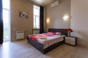 a bedroom with a large bed with red sheets at Malon Apartments in Kharkiv