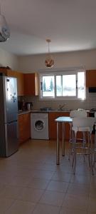 a kitchen with a table and a refrigerator at Summer Breeze - Cheerful 2 bedroom villa with pool in Ayia Napa