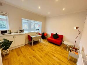 a living room with a red couch and a red chair at NEW modernised flat in the heart of Leigh on Sea in Southend-on-Sea