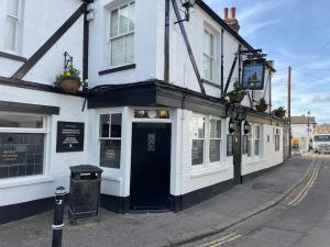 un edificio blanco con una puerta negra en una calle en NEW modernised flat in the heart of Leigh on Sea, en Southend-on-Sea