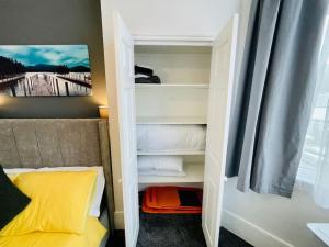 Dormitorio pequeño con cama y armario en NEW modernised flat in the heart of Leigh on Sea, en Southend-on-Sea