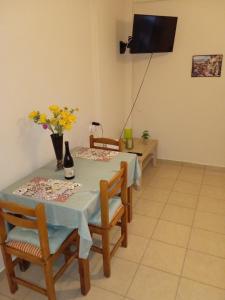 a dining room with a table and chairs and a television at Popi' s apartment 50 metres from the sea! in Sozopoli