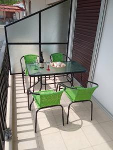 a glass table and chairs on a balcony at Popi' s apartment 50 metres from the sea! in Sozopoli