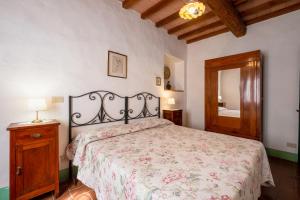um quarto com uma cama com colcha floral em Appartamento Oleandro em Radicofani