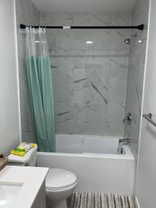 卡爾加里的住宿－Beautiful 2 bedroom home away from home，带浴缸、卫生间和淋浴的浴室。