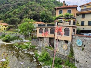 a building with flowers on the side of a river at Ellera Suite con Parcheggio Privato - Albisola Superiore in Stella
