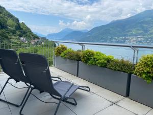 - deux chaises sur un balcon avec vue sur les montagnes dans l'établissement Residence Il Poggio, à Dorio