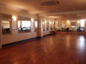 an empty ballroom with a wooden floor and tables at The Riviera Hotel & Apartments - Alum Chine in Bournemouth