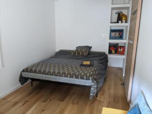 un piccolo letto in una camera con pavimento in legno di Chez Agathe et Mathieu a Le Mans
