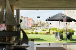 einen Blick auf einen Park von einem Restaurant mit Sonnenschirm in der Unterkunft Hotel Cristal Praia Resort & SPA in Praia da Vieira