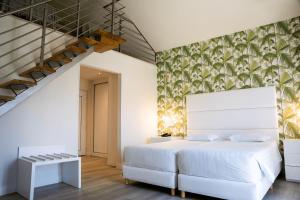 um quarto com uma cama branca e uma escada em Hotel Cristal Praia Resort & SPA na Praia da Vieira