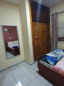 Dormitorio pequeño con cama y espejo en Appartement Cosy & Chill, en Douala