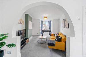 uma sala de estar com um sofá amarelo e uma televisão em Fabulous and Stylish House in Nottingham em Mansfield
