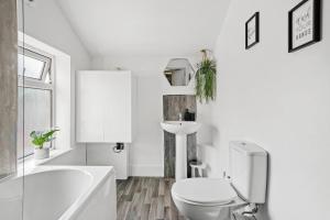 a white bathroom with a toilet and a sink at Fabulous and Stylish House in Nottingham in Mansfield