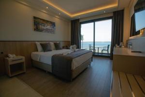 a hotel room with a bed and a large window at Polaris Otel & Beach Club in Mersin