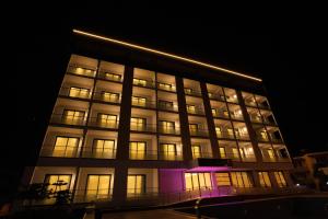 a tall building with lights on it at night at Polaris Otel & Beach Club in Mersin