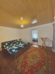 1 dormitorio con cama, alfombra y ventana en Tsatʼer Guest House, en Tsatʼer