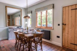 een eetkamer met een tafel en stoelen en een raam bij Margo's Cottage in Orford