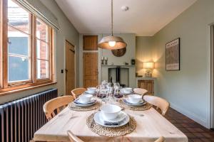 a dining room with a wooden table and chairs at Margo's Cottage, Orford in Orford +30 photos