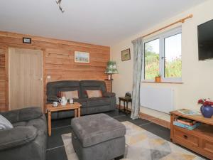 uma sala de estar com um sofá e uma televisão em Watermead Lodge em Taunton