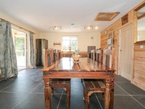 uma sala de jantar com uma mesa de madeira e cadeiras em Watermead Lodge em Taunton