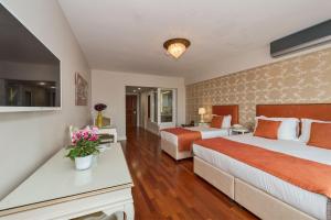 una habitación de hotel con 2 camas y una mesa con flores en Suitel Bosphorus Taksim, en Estambul