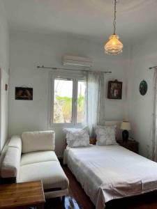 um quarto com 2 camas, um sofá e uma janela em Traditional home in Mauromati em Mavrommátion