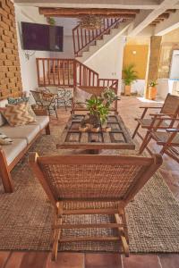 Casa Pumata Barichara في باريكارا: غرفة معيشة مع أريكة وطاولات وكراسي