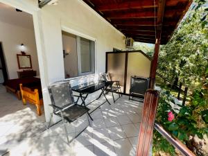 a patio with chairs and a table on a house at Studios Elena in Skala Rachoniou