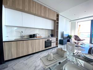 a kitchen with white cabinets and a sink and a table at ICON - Private Holiday Apartments in Limassol