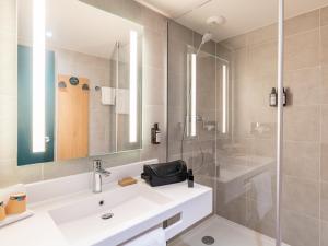 a bathroom with a sink and a shower at B&B HOTEL Lyon Nord 4 étoiles in Dardilly