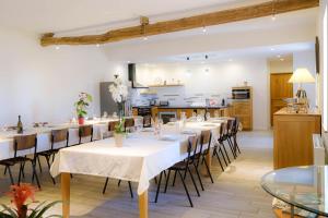 una sala da pranzo con tavoli e sedie e una cucina di Le Domaine des Gauliers a Chavagnes